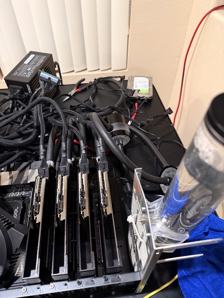 Four waterblocked RTX PRO 6000 Blackwell GPUs on an open test bench